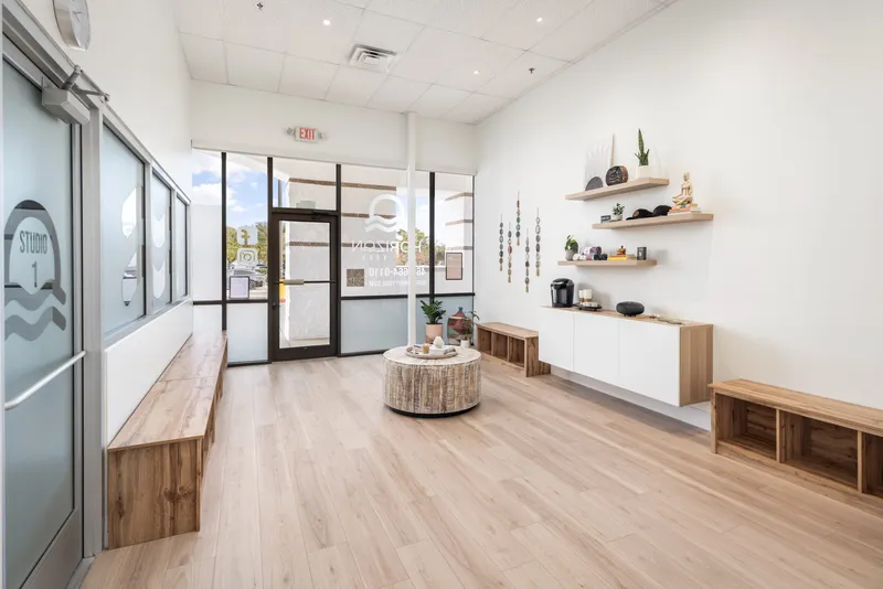 The Horizon Hot Yoga waiting area: benches, pale oak floor and the front door